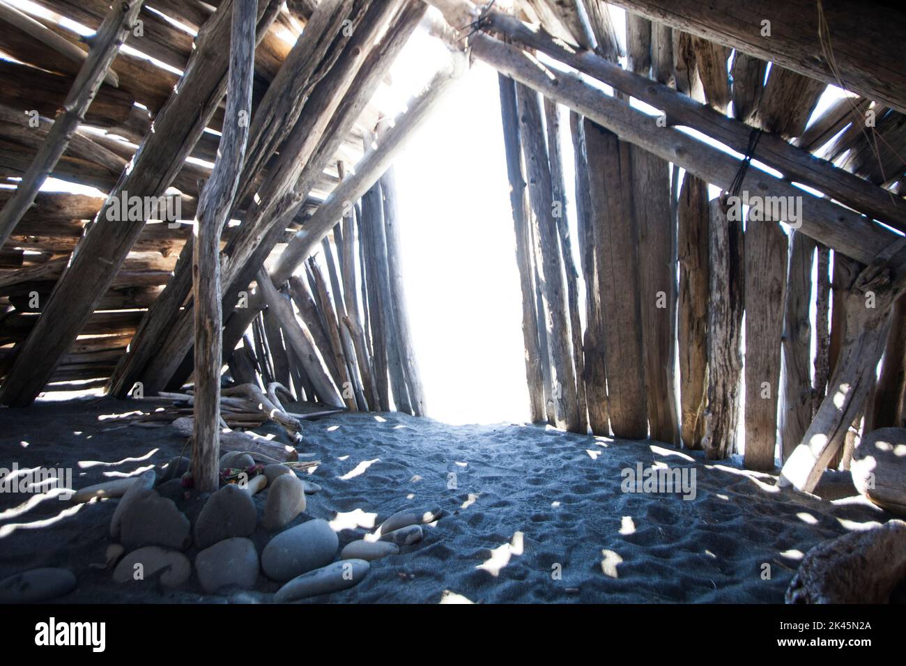 Driftwood hut interior on sand. Stock Photo