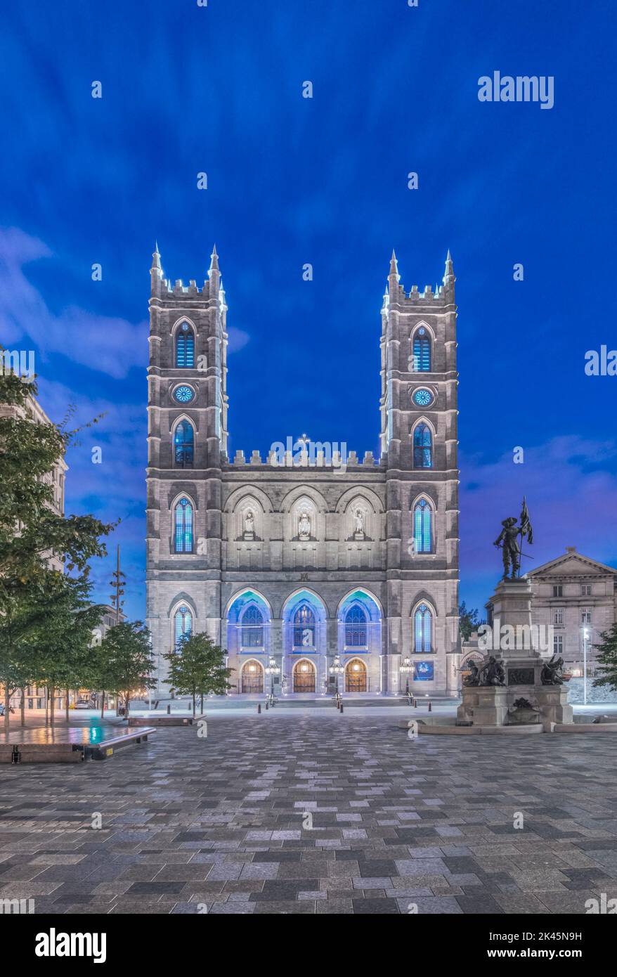 The Notre Dame Basilica, lit up at dusk in the city square in the Old Town of Montreal. Stock Photo