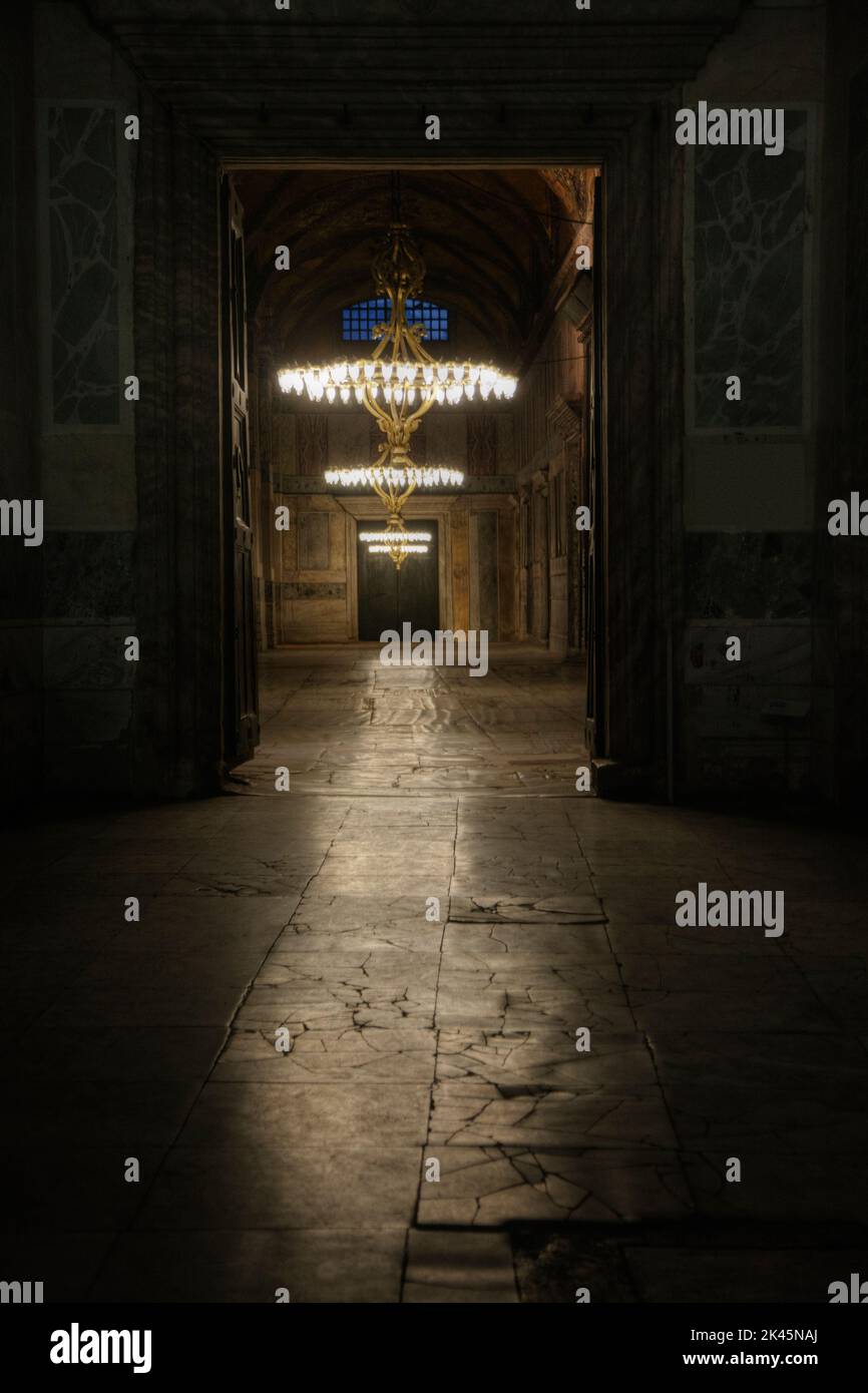 Hagia Sophia Grand Mosque, the dark interior of a historic building, former mosque and church, flagstones and chandeliers with bright lights. Stock Photo