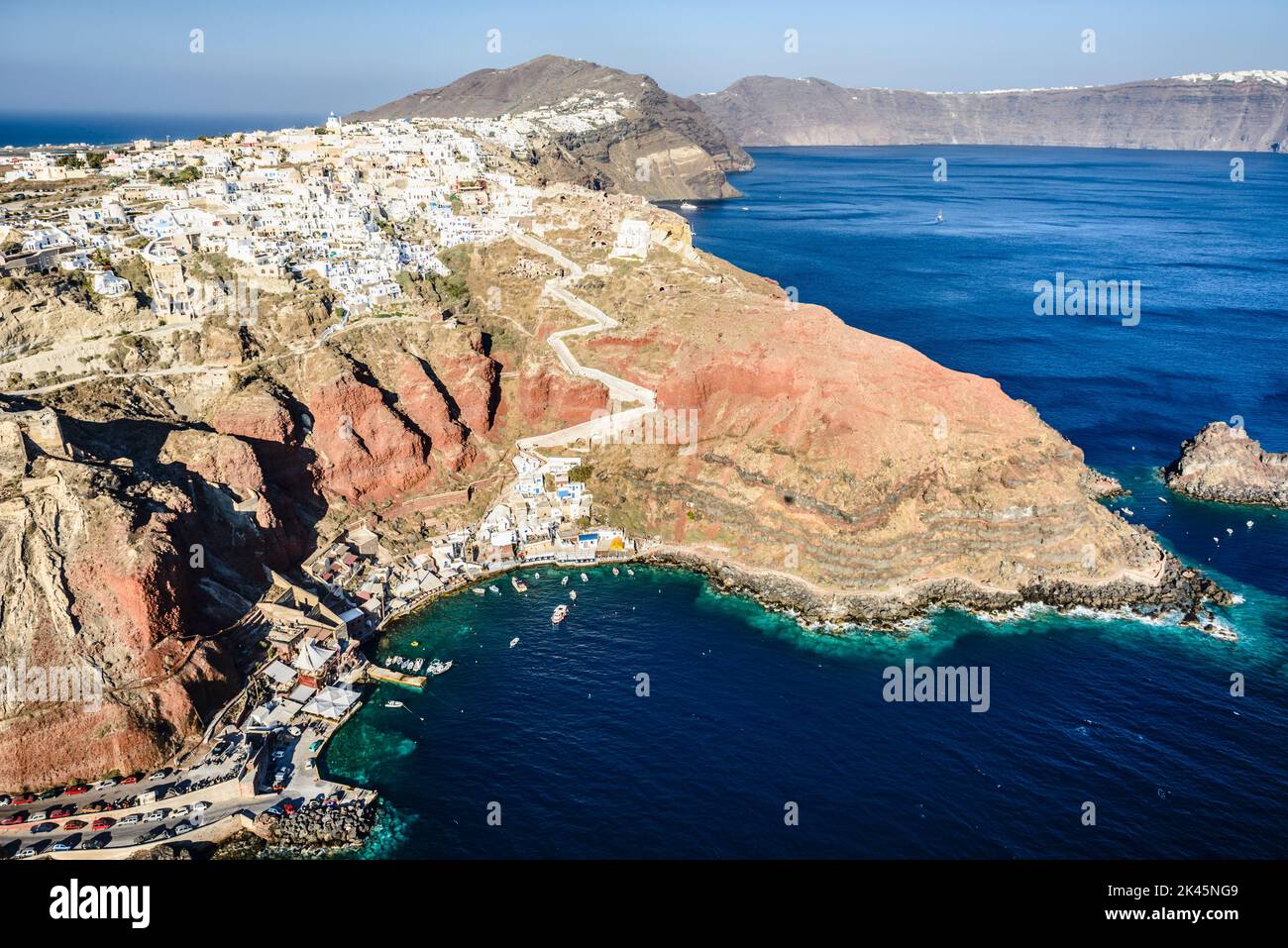Aerial view of an island in the deep blue seas of the Aegean sea, rock formations, whitewashed houses perched on the cliffs. Stock Photo