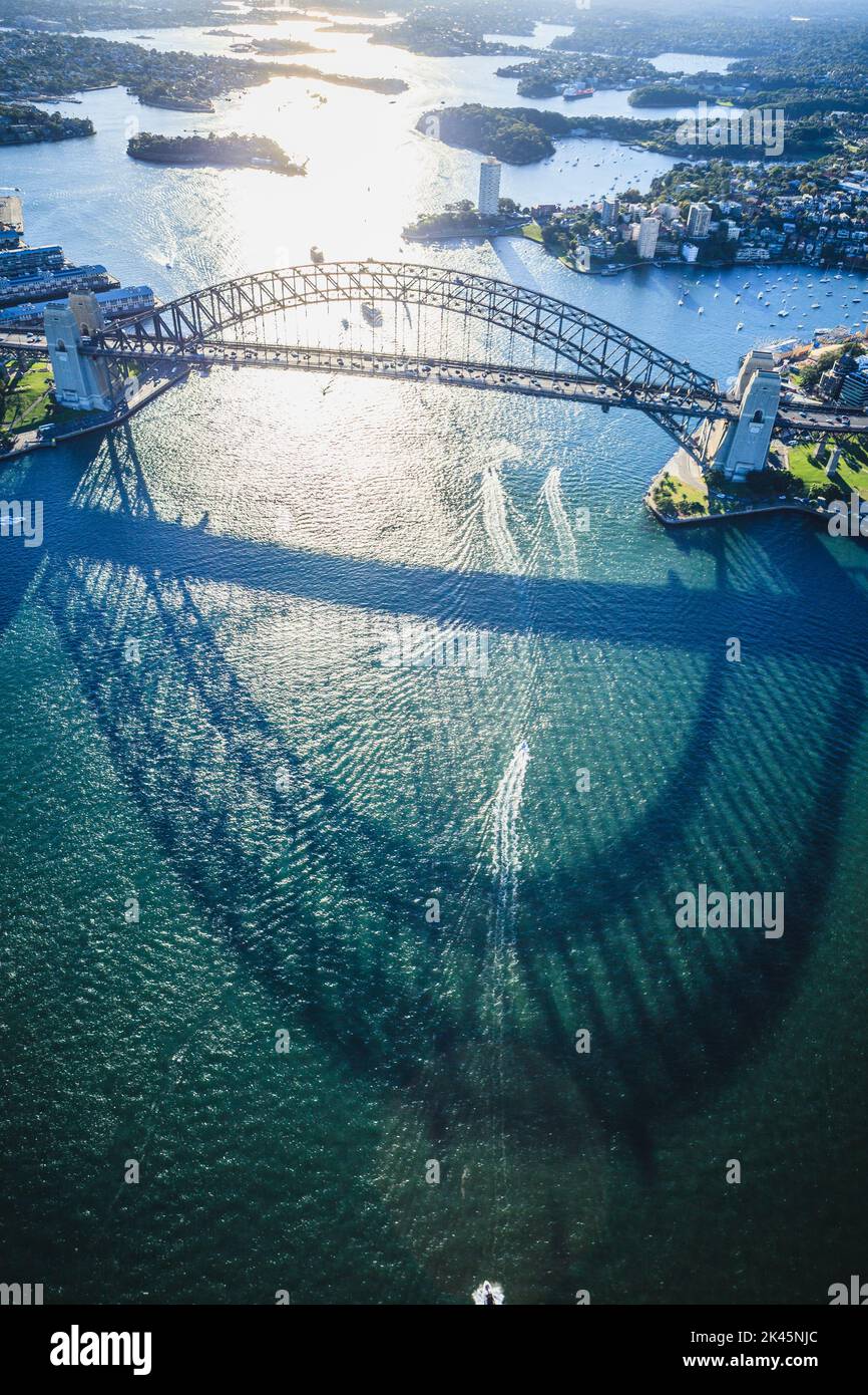 The Sydney Harbour Bridge, the shadow of the arch on the water, and aerial view of the landscape. Stock Photo