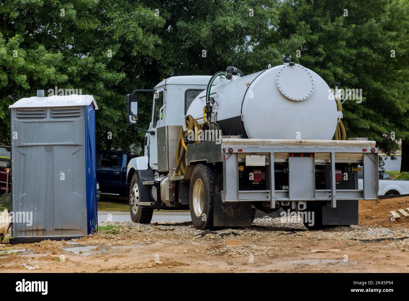 A septic truck is being used to clean portable restrooms Stock Photo