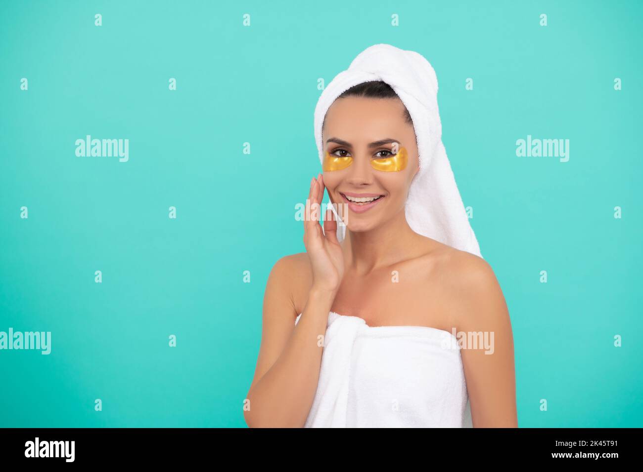 young woman in shower towel with collagen patch Stock Photo