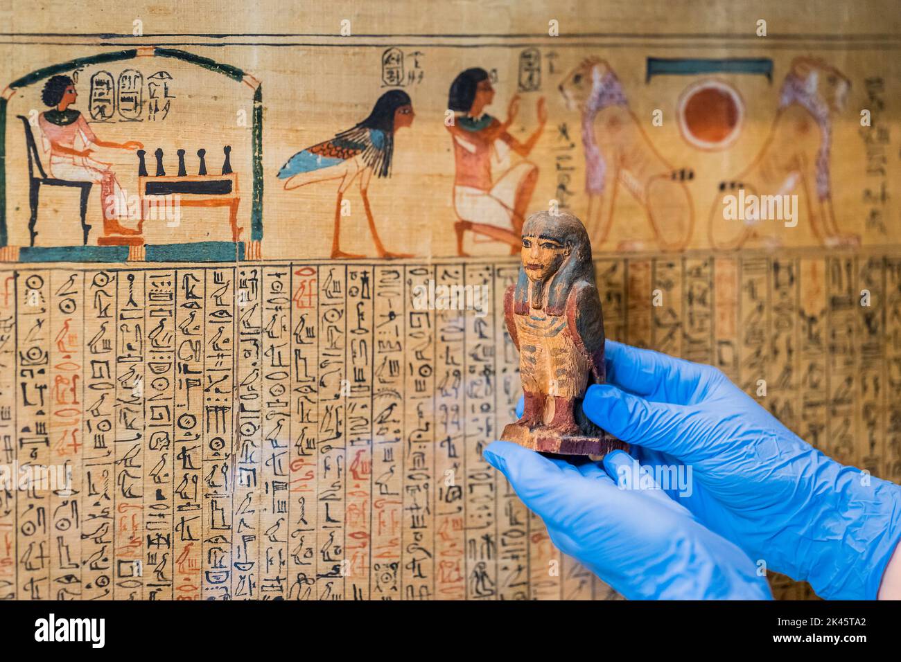 London, UK. 26th Sep, 2022. An ancient Egyptian amulet is prepared for display in front of the 3,000 year old papyrus, the Book of the Dead of Queen Nedjmet - the British Museum prepares for the major exhibition Hieroglyphs: unlocking ancient Egypt which opens 13 October 2022. Credit: Guy Bell/Alamy Live News Stock Photo