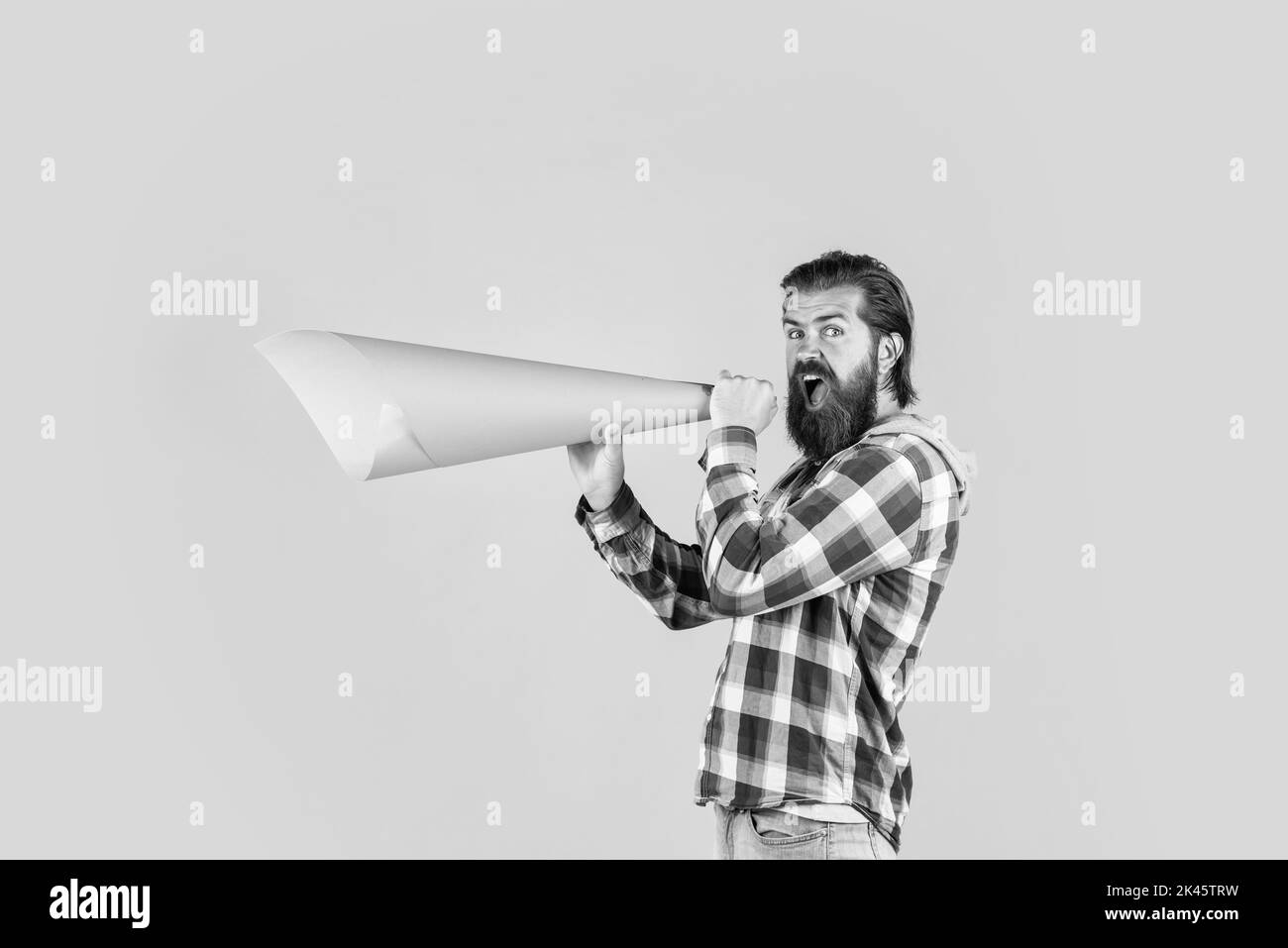 attention please. male speak in megaphone. hipster checkered shirt for bearded guy with loudspeaker. unshaven brutal man with beard. advertising and Stock Photo