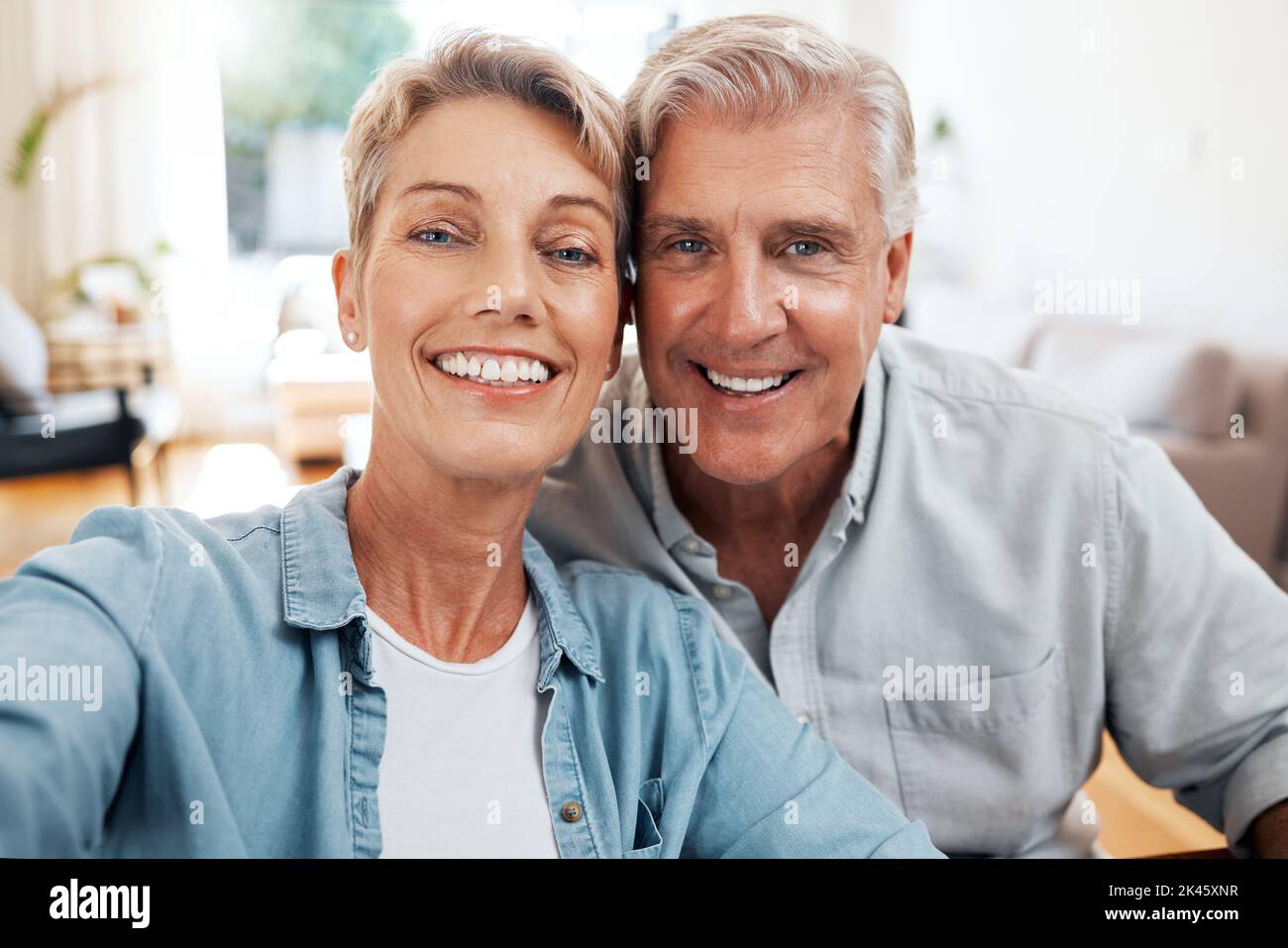 Senior couple selfie portrait in home lounge for love, care and relaxing day together. Faces of smile man, happy woman and retirement people enjoying Stock Photo