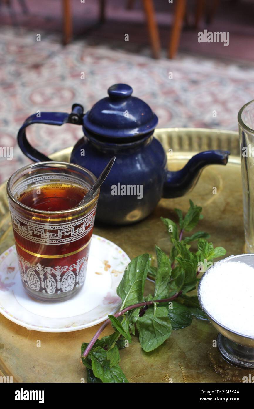 A glass of tea, a teapot, mint on a table at El Fishawi Cafe, Khan Al Khalili Bazaar, Cairo, Egypt Stock Photo