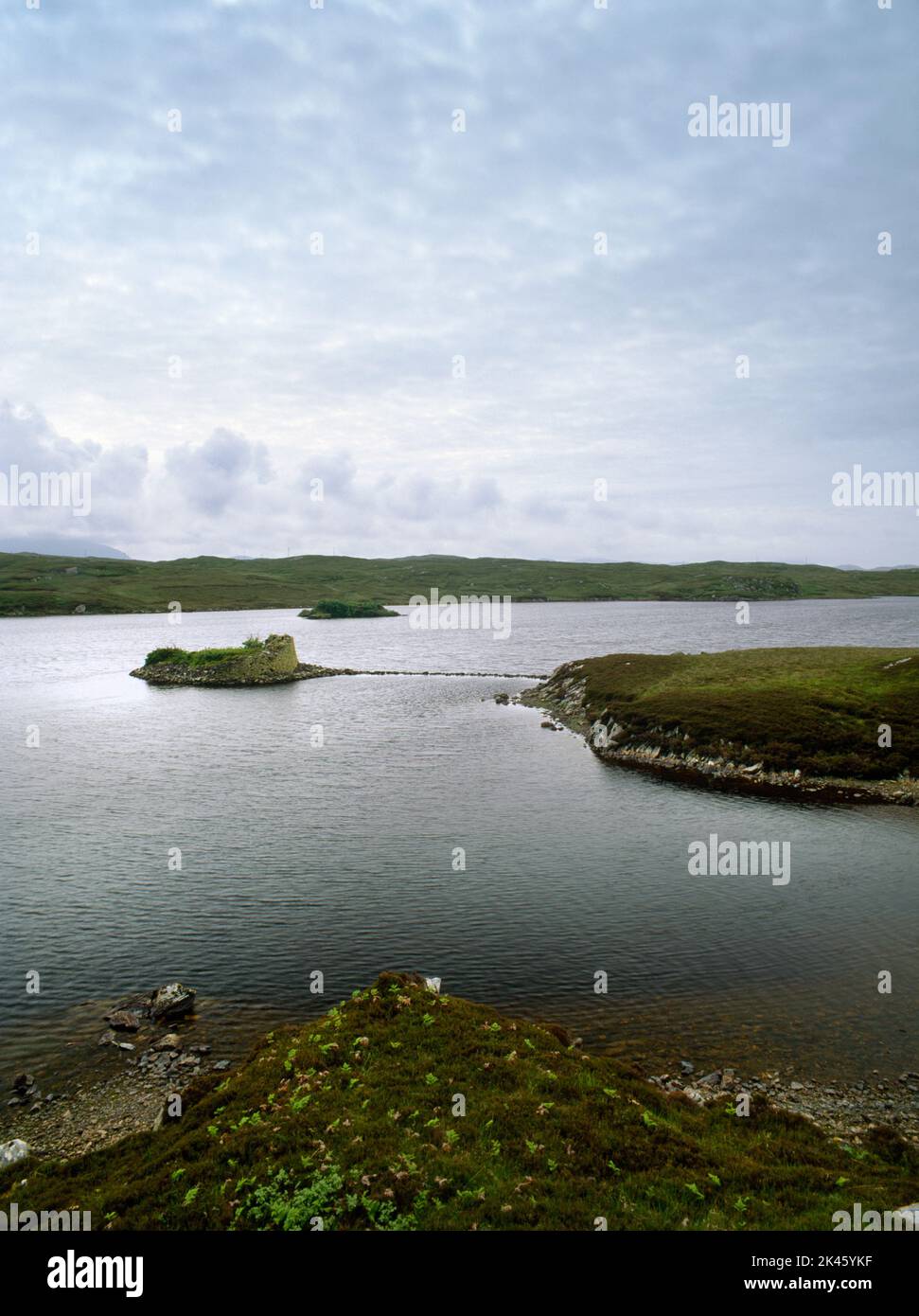 View WSW of Dun Baravat Iron Age galleried dun on a small island in Loch Barabhat, Bernera, Isle of Lewis, Scotland, UK, linked to shore by a causeway Stock Photo