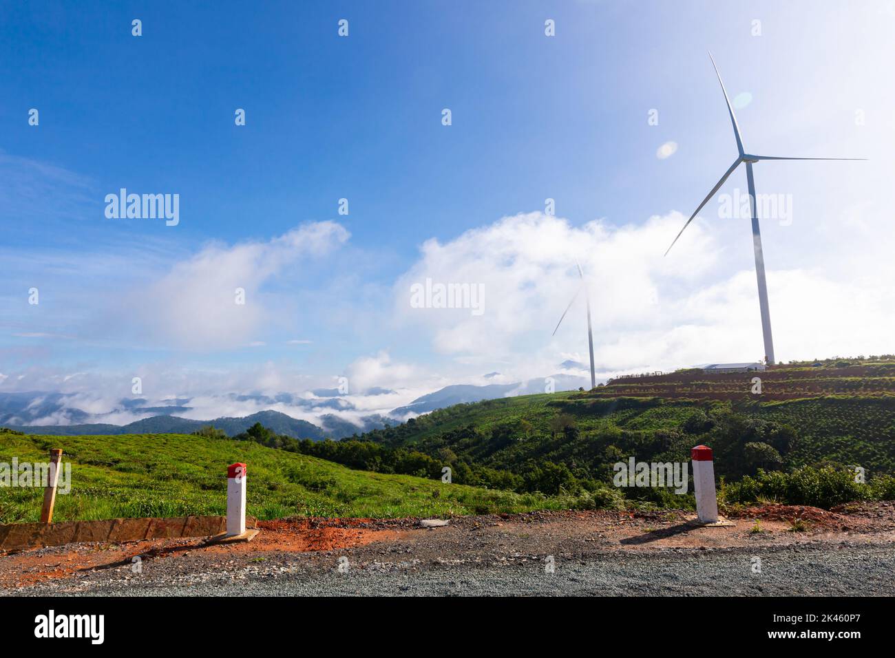Renewable energy wind turbines windmill isolated on the beautiful blue sky, white clouds and on the tea fields in Da Lat city, Lam Dong, Viet Nam Stock Photo