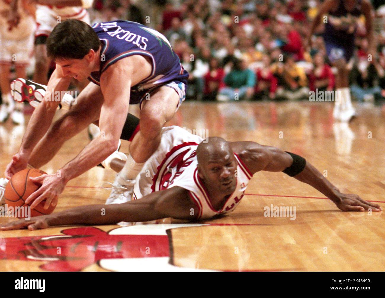 NBA superstar Michael Jordan of the Chicago Bulls scrambles for a loose ball with Utah Jazz star John Stockton in 1998. Stock Photo