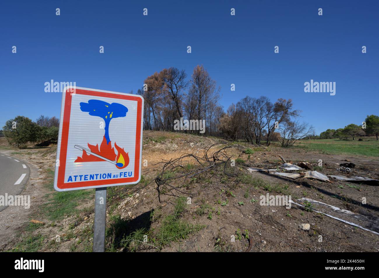 Sign warning of fire with damaged woodland  starting to recover form Summer wild fires D81 road,close to Graveson, Provence, France. September 2022. Stock Photo