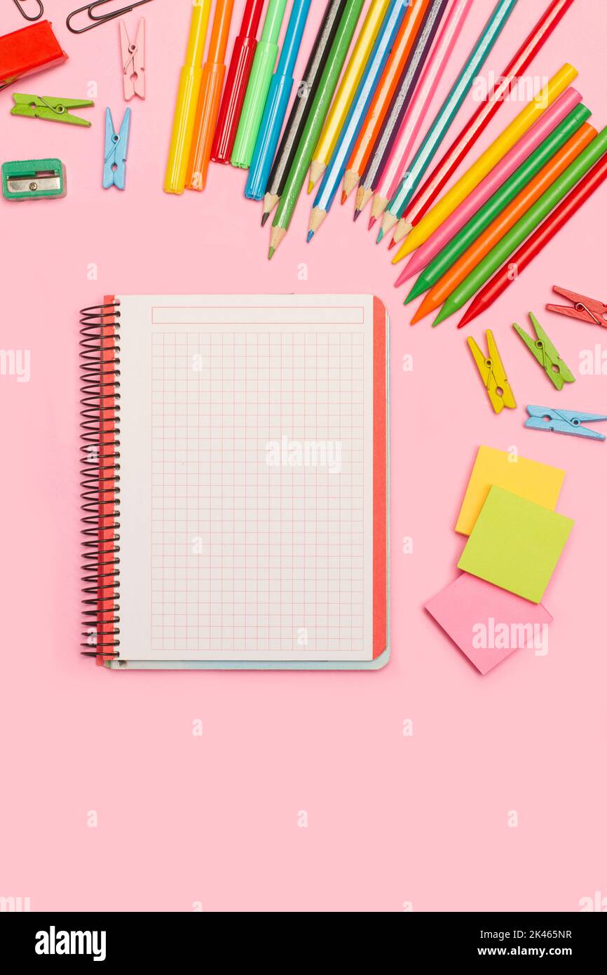 Blank open graph paper notebook and school utensils on a pink background with copy space Stock Photo