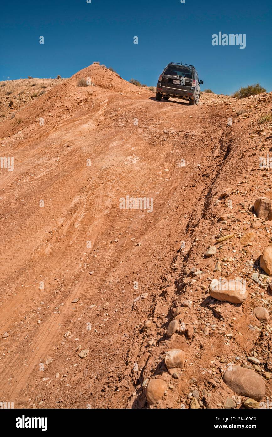SUV on dirt track to Three Finger Canyon, San Rafael Reef edge of San Rafael Swell, Navajo and Wingate Sandstone, San Rafael Reef Wilderness, Utah USA Stock Photo
