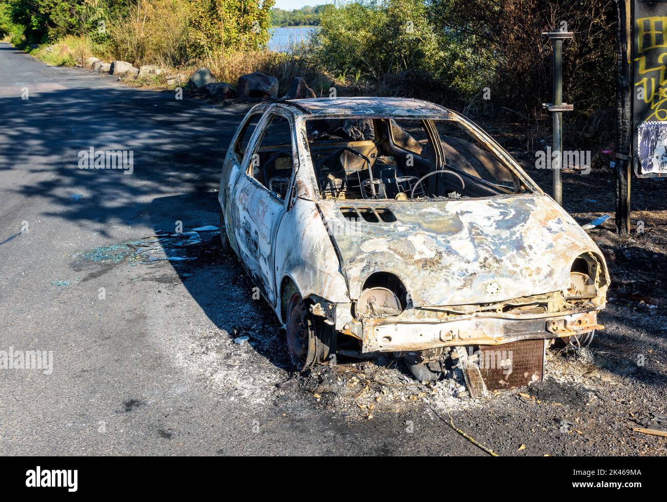 A city car burned out in a discreet street of a sensitive neighborhood. Stock Photo