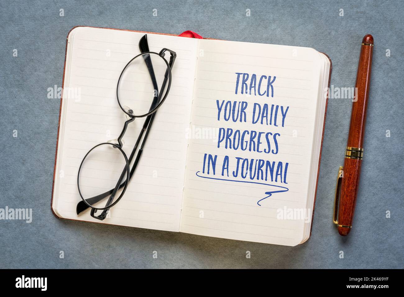 track your daily progress in a journal - inspirational advice in a notebook, journaling and personal development progress Stock Photo