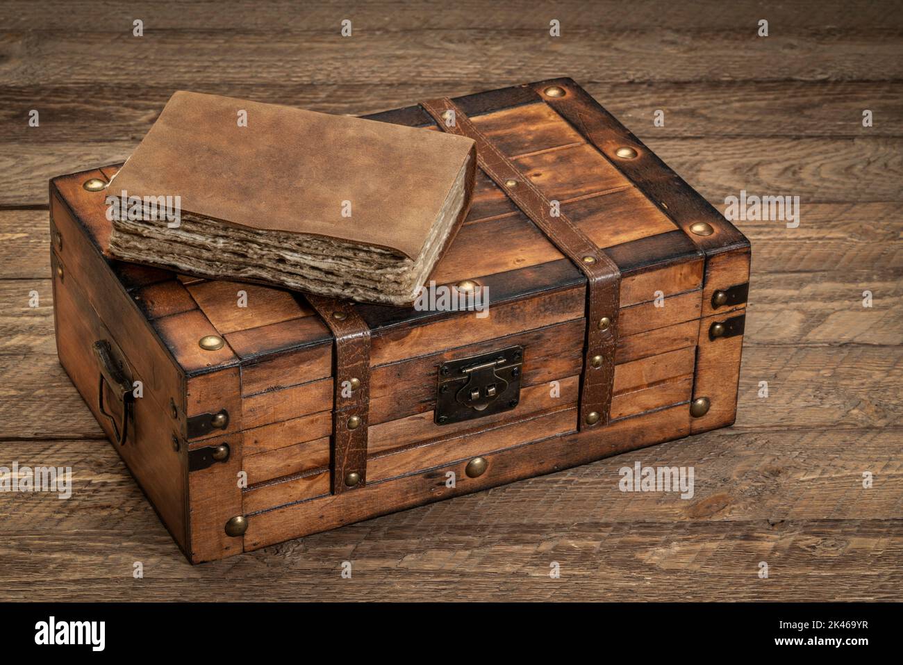 retro decorative case or storage box on wooden rustic table with am old journal or book Stock Photo