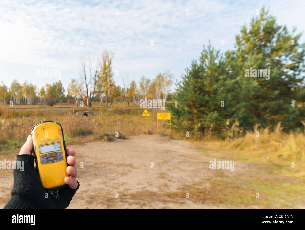 Yellow geiger counter on the hands shows blank space level near