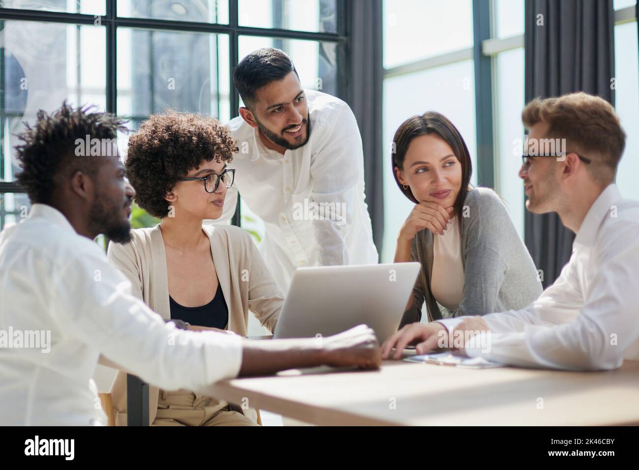 Employees working at computer together, discussing content Stock Photo