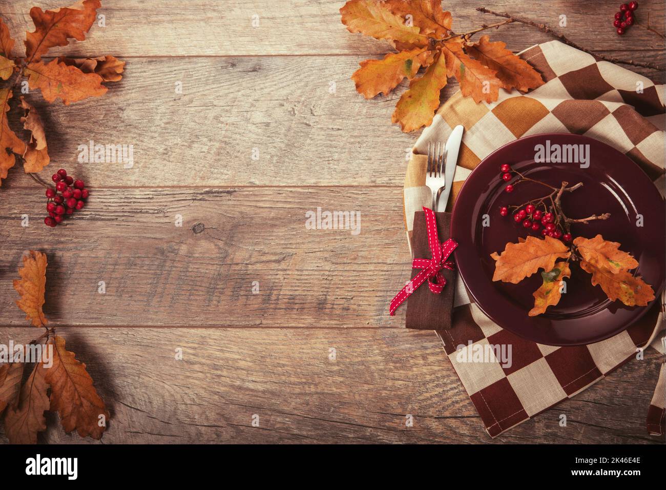 Napkin, cutlery and autumn leaves on a wooden background with space to copy. The concept of Thanksgiving, Halloween Stock Photo