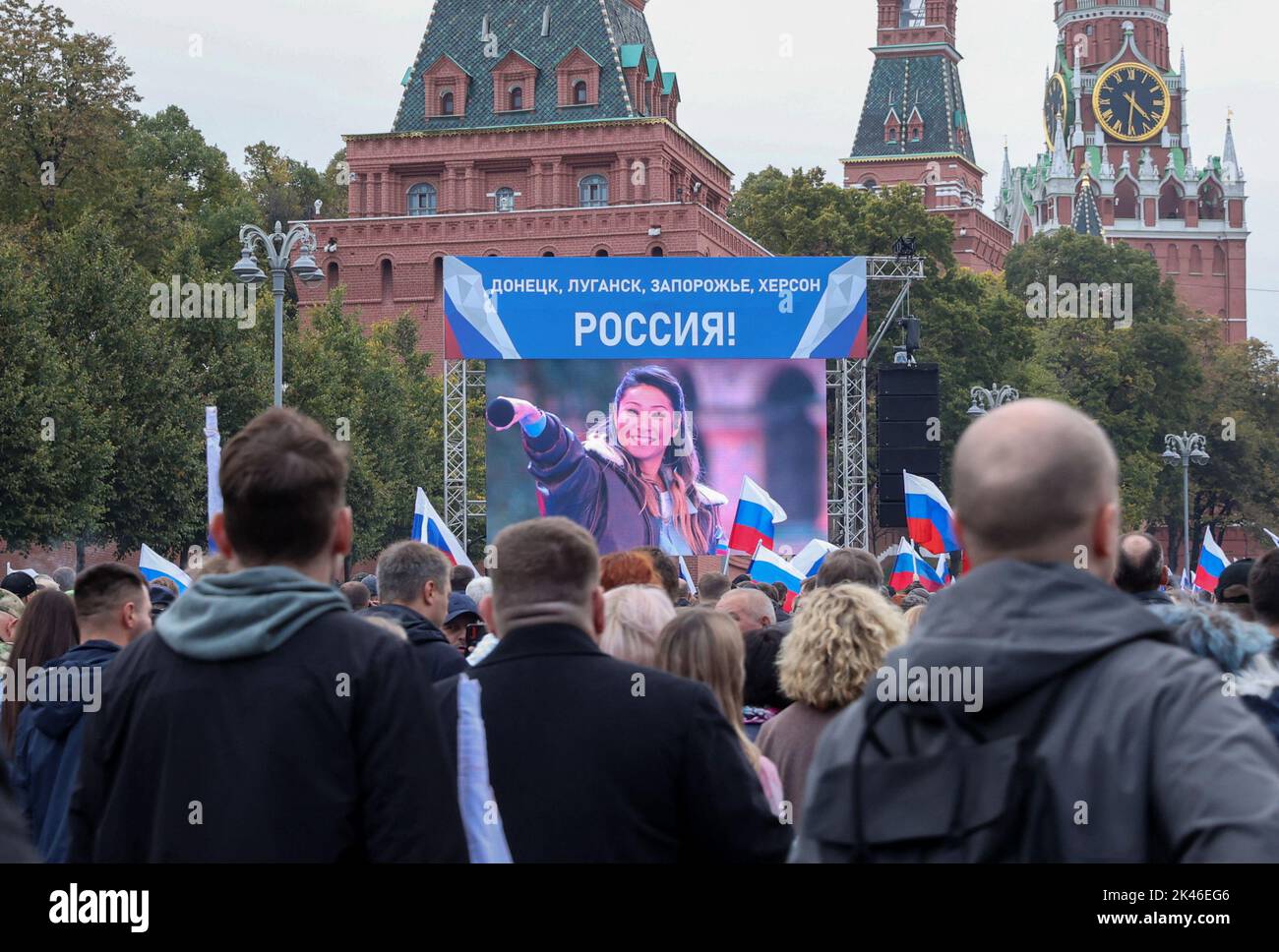 People attend a concert marking the declared annexation of the Russian-controlled territories of four Ukraine's Donetsk, Luhansk, Kherson and Zaporizhzhia regions, after holding what Russian authorities called referendums in the occupied areas of Ukraine that were condemned by Kyiv and governments worldwide, near the Kremlin Wall in central Moscow, Russia, September 30, 2022. A slogan on the screen reads: 'Donetsk, Luhansk, Zaporizhzhia, Kherson - Russia!'  REUTERS/REUTERS PHOTOGRAPHER Stock Photo