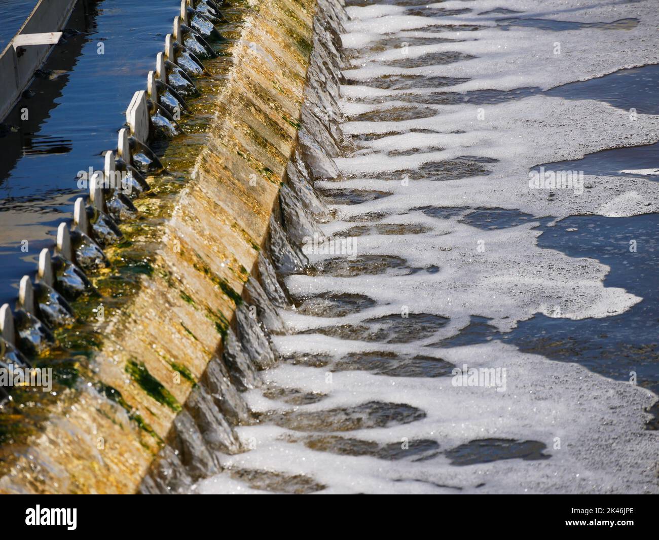 treated water flowing thru a weir in a sedimentation trank in a waste water treatment plant