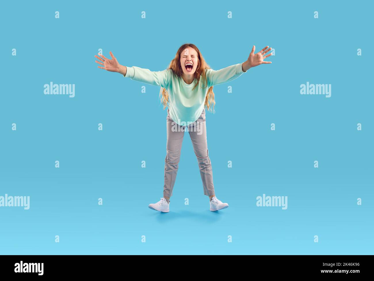 Funny emotional woman stretches her hands to camera, excited to see you and screaming for joy. Stock Photo