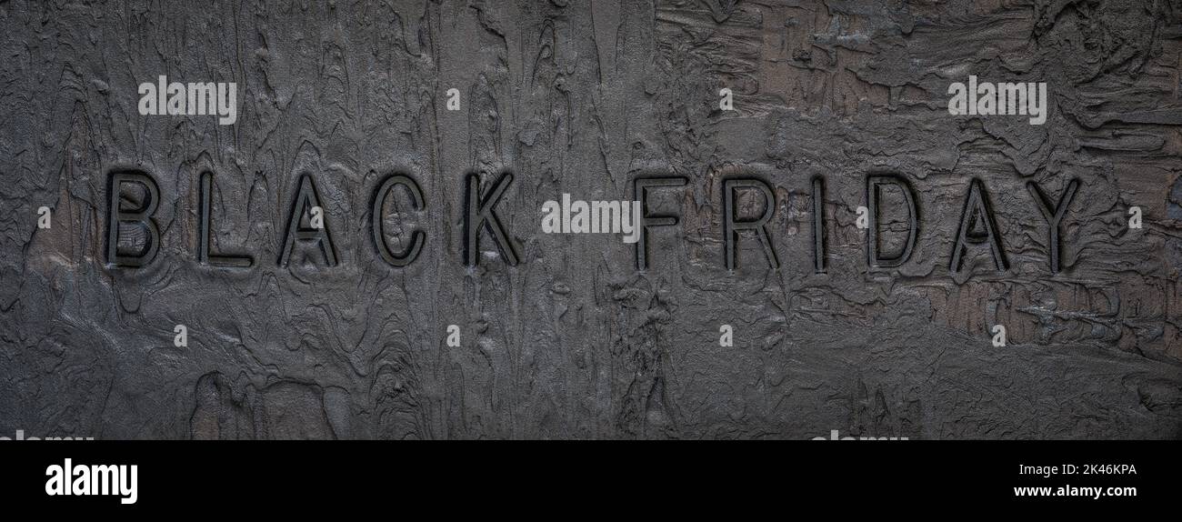 Black or dark gray grainy plaster texture background with text Black Friday Stock Photo