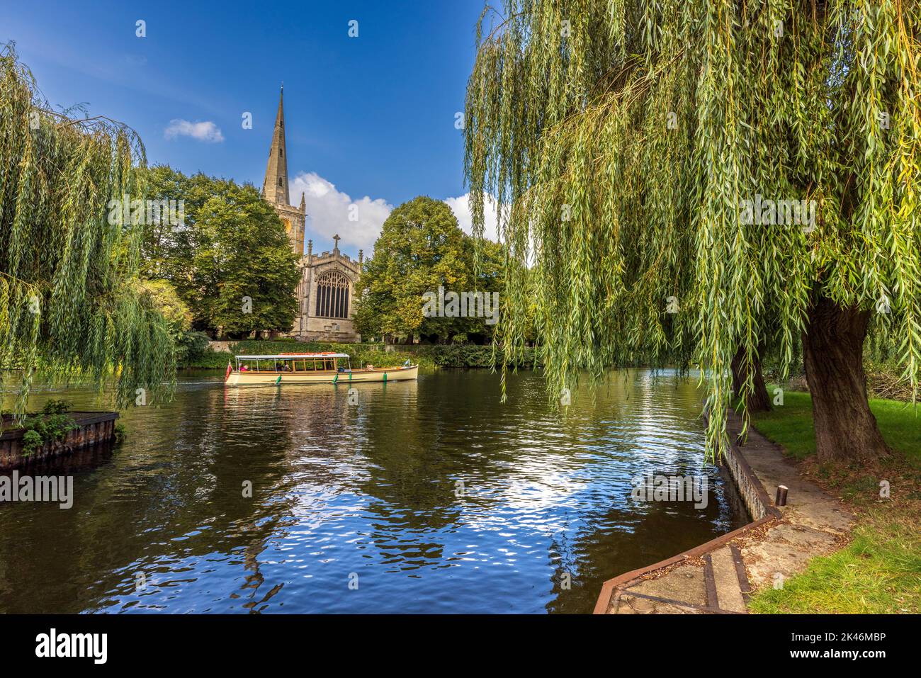 A River Cruise boat and Holy Trinity church across the river at Stratford Upon Avon, Warwickshire, England Stock Photo