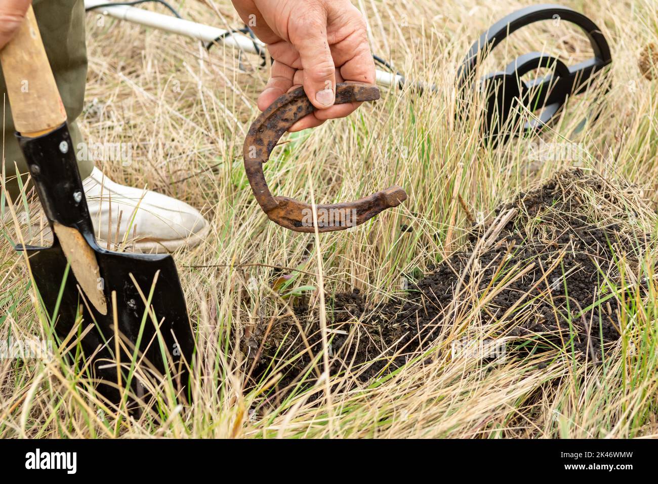 Man with electronic metal detector device working on outdoors. Closeup