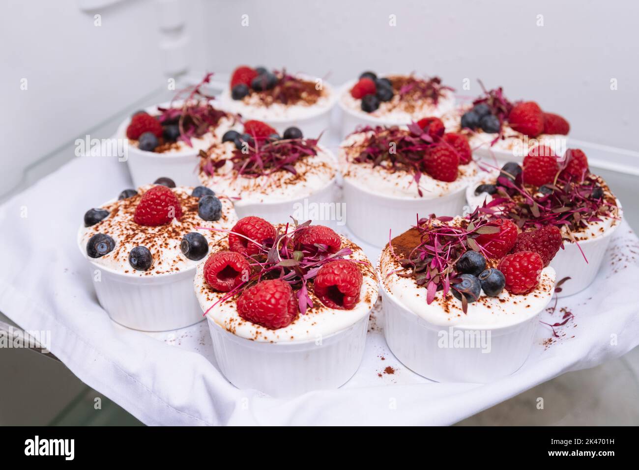 Desserts on a tray in the refrigerator. White ramekins with chilled