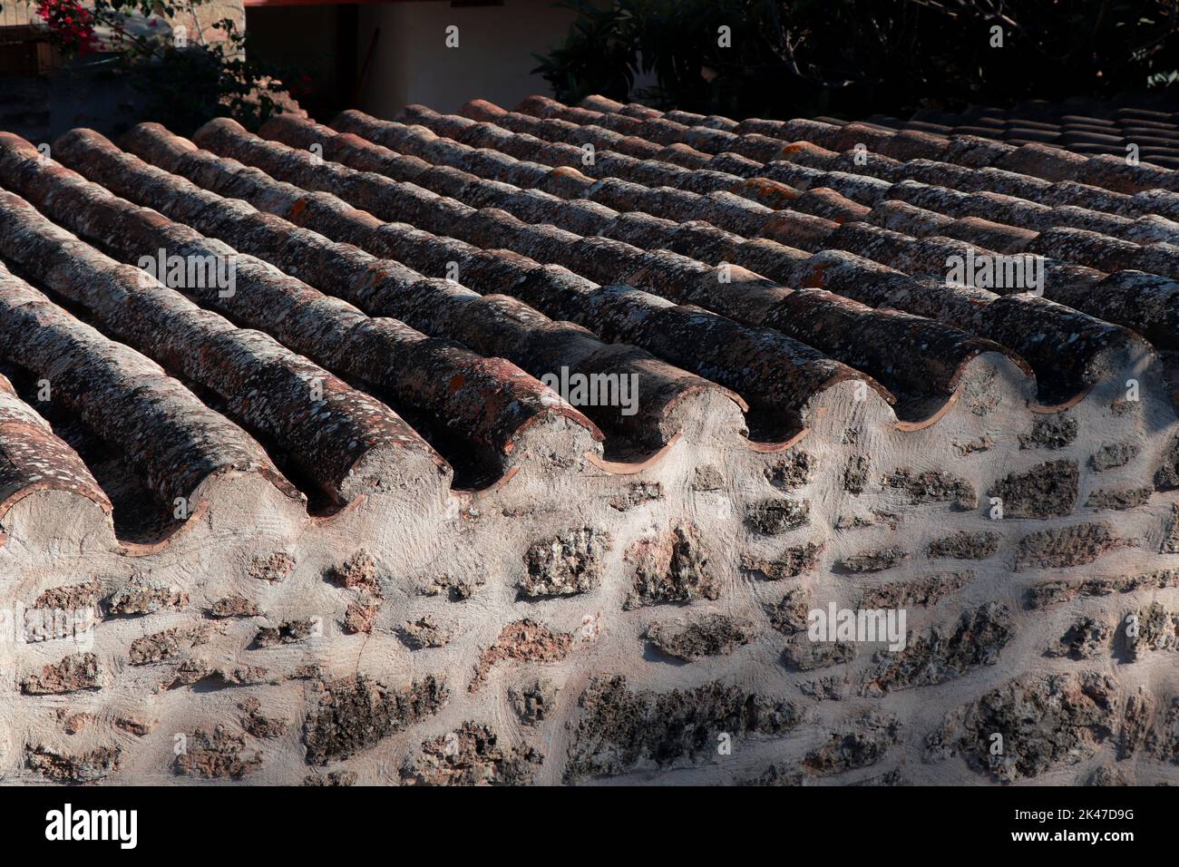 Roof tiles with lichens of an old traditional Spanish village house.   Old Tile Roof Texture Spain. Alcudia old tile roof. Stock Photo