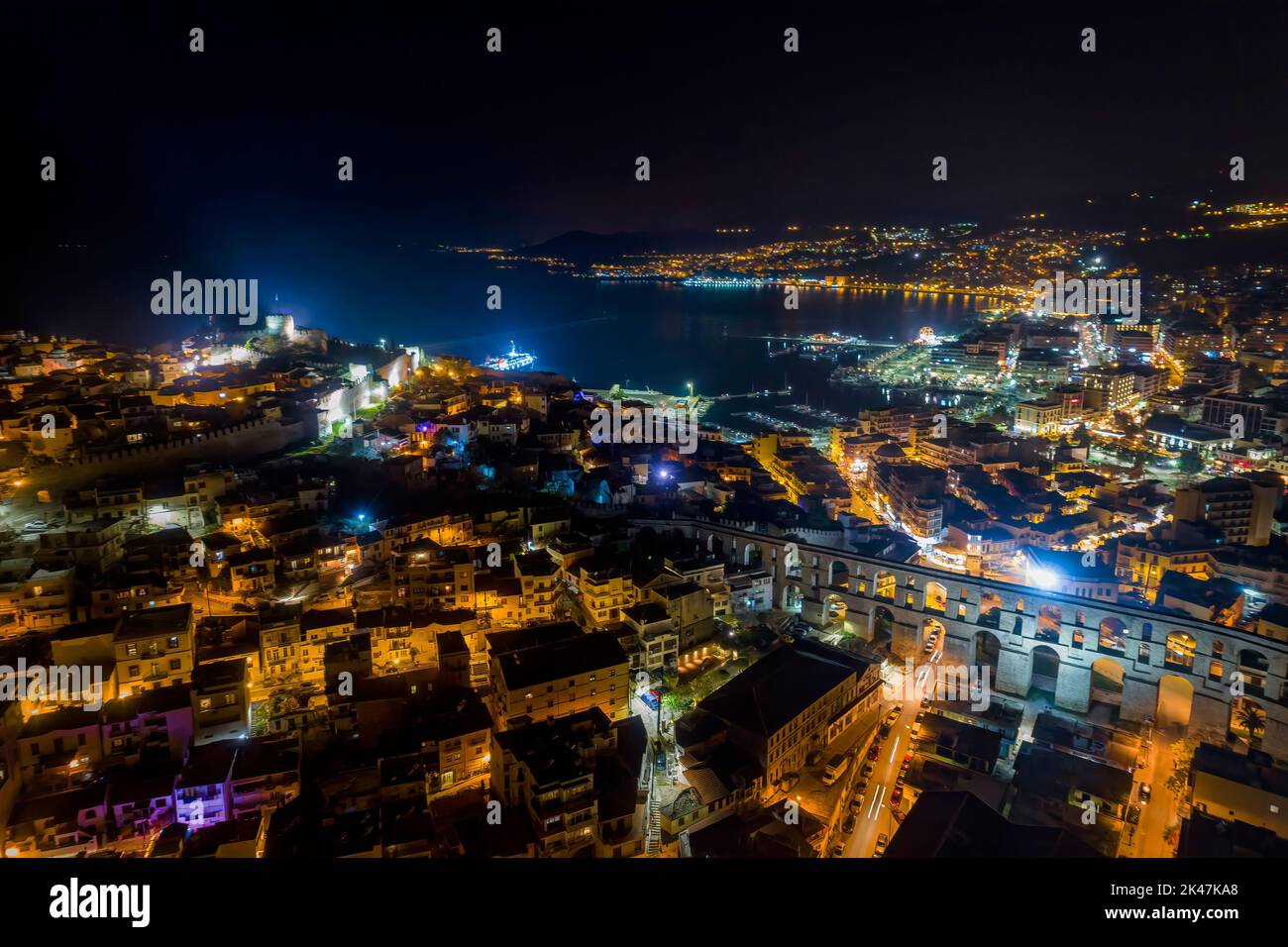 Aerial view the city of Kavala at night, in northern Greece, ancient aqueduct Kamares, homes and medieval city wall Stock Photo