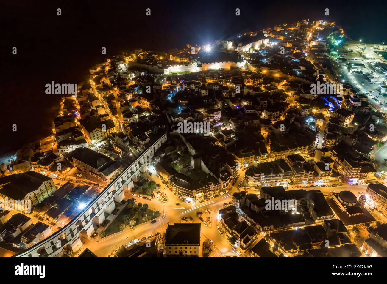 Aerial view the city of Kavala at night, in northern Greece, ancient aqueduct Kamares, homes and medieval city wall Stock Photo