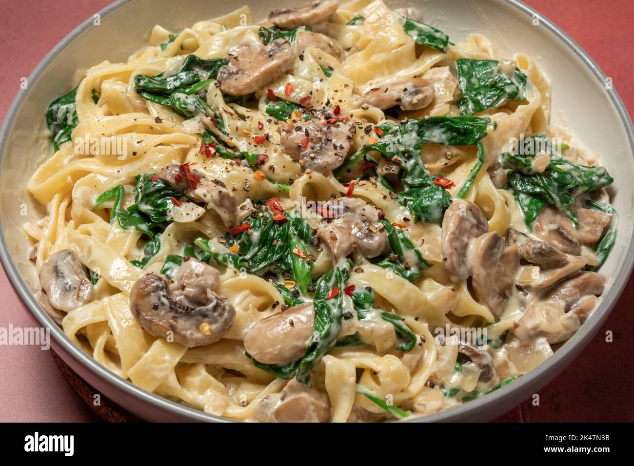Creamy mushroom and spinach pasta Stock Photo