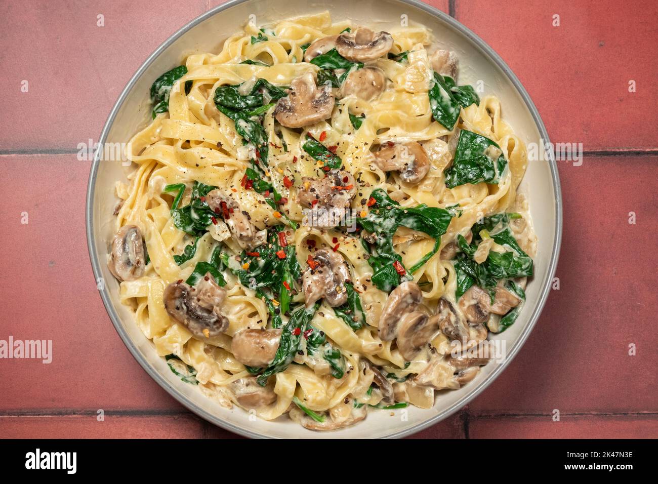 Creamy mushroom and spinach pasta from above Stock Photo