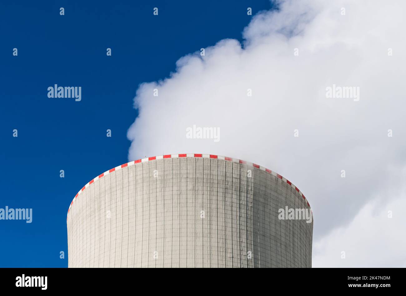 Top of cooling tower with warning red broken line and white steam plume on blue sky background. Waste heat rejection from nuclear power plant to air. Stock Photo