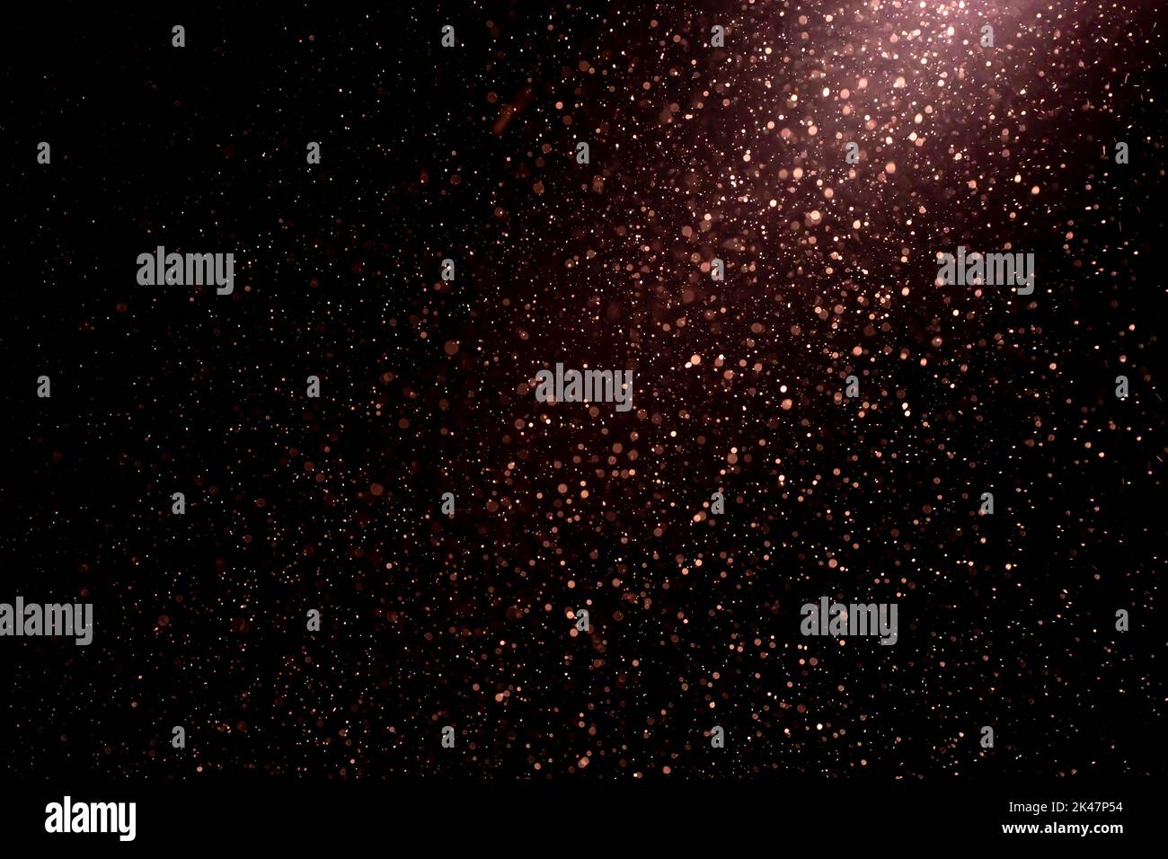 Dust particles on black background with light ray. Purple glittering ...