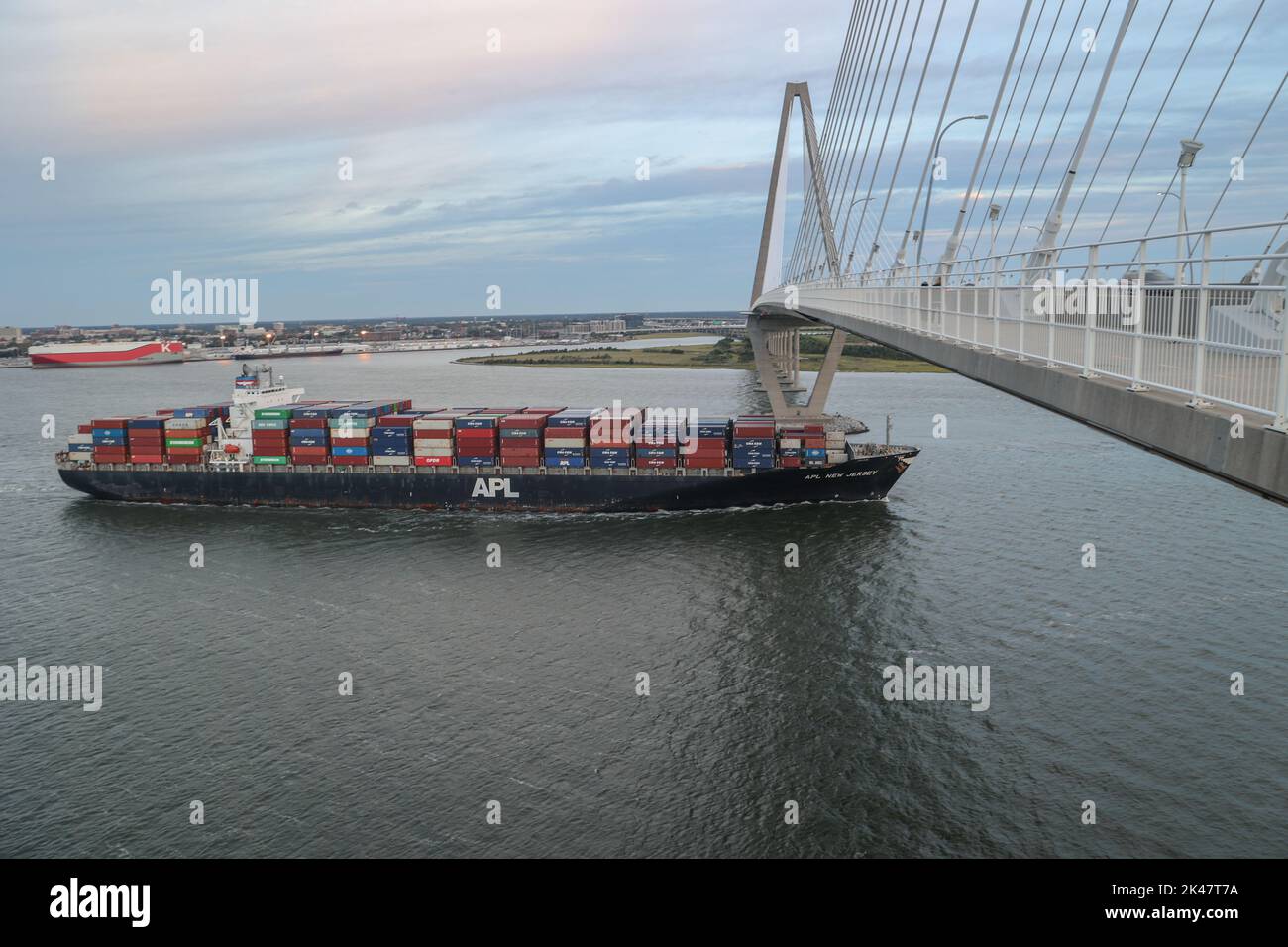 A container vessel travels under the Arthur Ravenel Jr. Bridge, which spans across the Cooper River in Charleston, S.C. The river is part of the Charleston Harbor Post 45 Deepening Project, which will make the Charleston Harbor deeper and wider to accommodate larger ships to call on the Port of Charleston. The project will make the channel the deepest on the East Coast of the United States at 52 feet. (U.S. Army photo by Patrick Bloodgood) Stock Photo