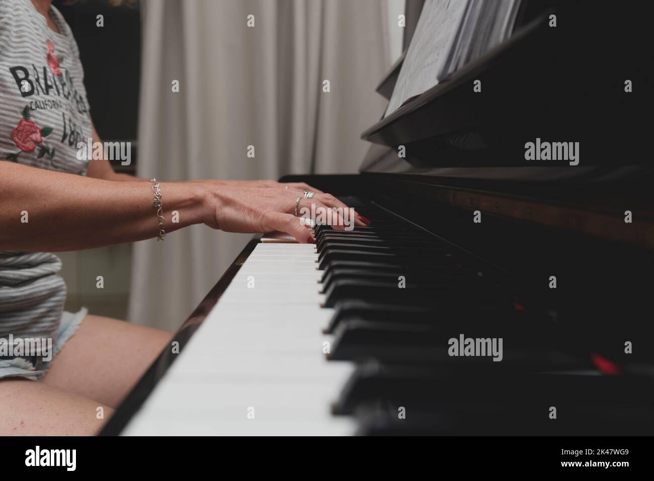 Beautiful Brazilian pianist woman touching piano keys, playing upright