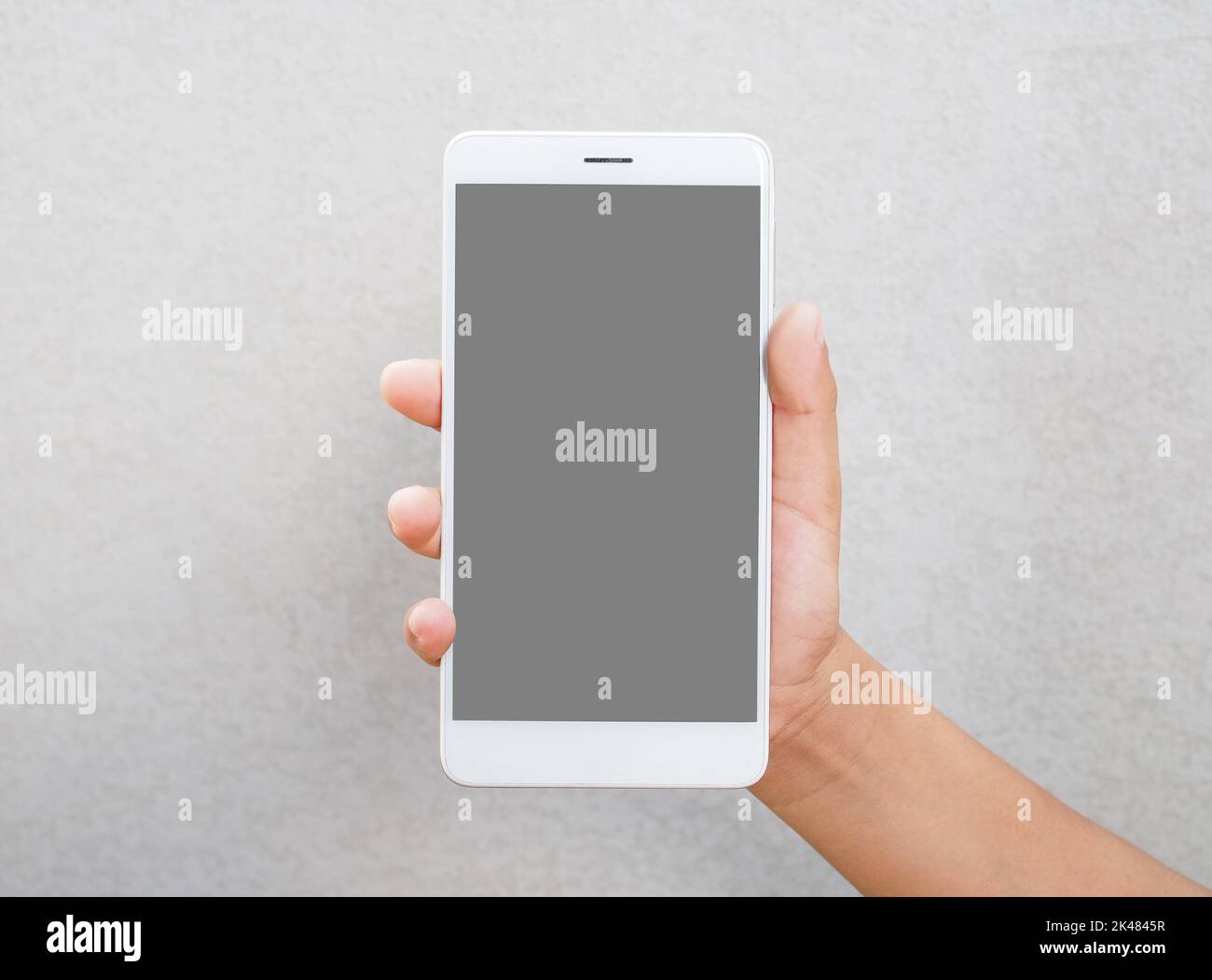 Human hand holding blank screen smart phone isolated on white