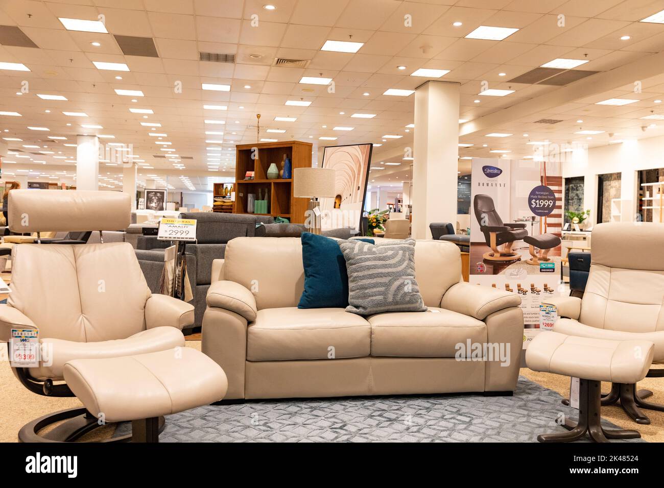 Harvey Norman Domayne furniture store, stressless leather recliner chair in beige leather with footstool, also two seater settee sofa,Sydney,Australia Stock Photo