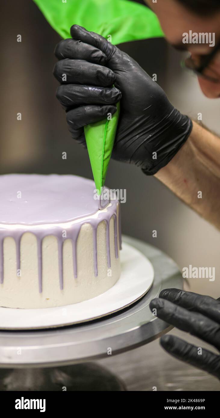 chef using using bag decorating a frosted icing cake Stock Photo Alamy