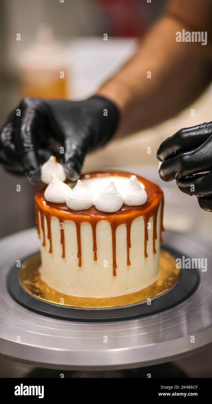 chef decorating the top of a frosted buttercream cake Stock Photo Alamy