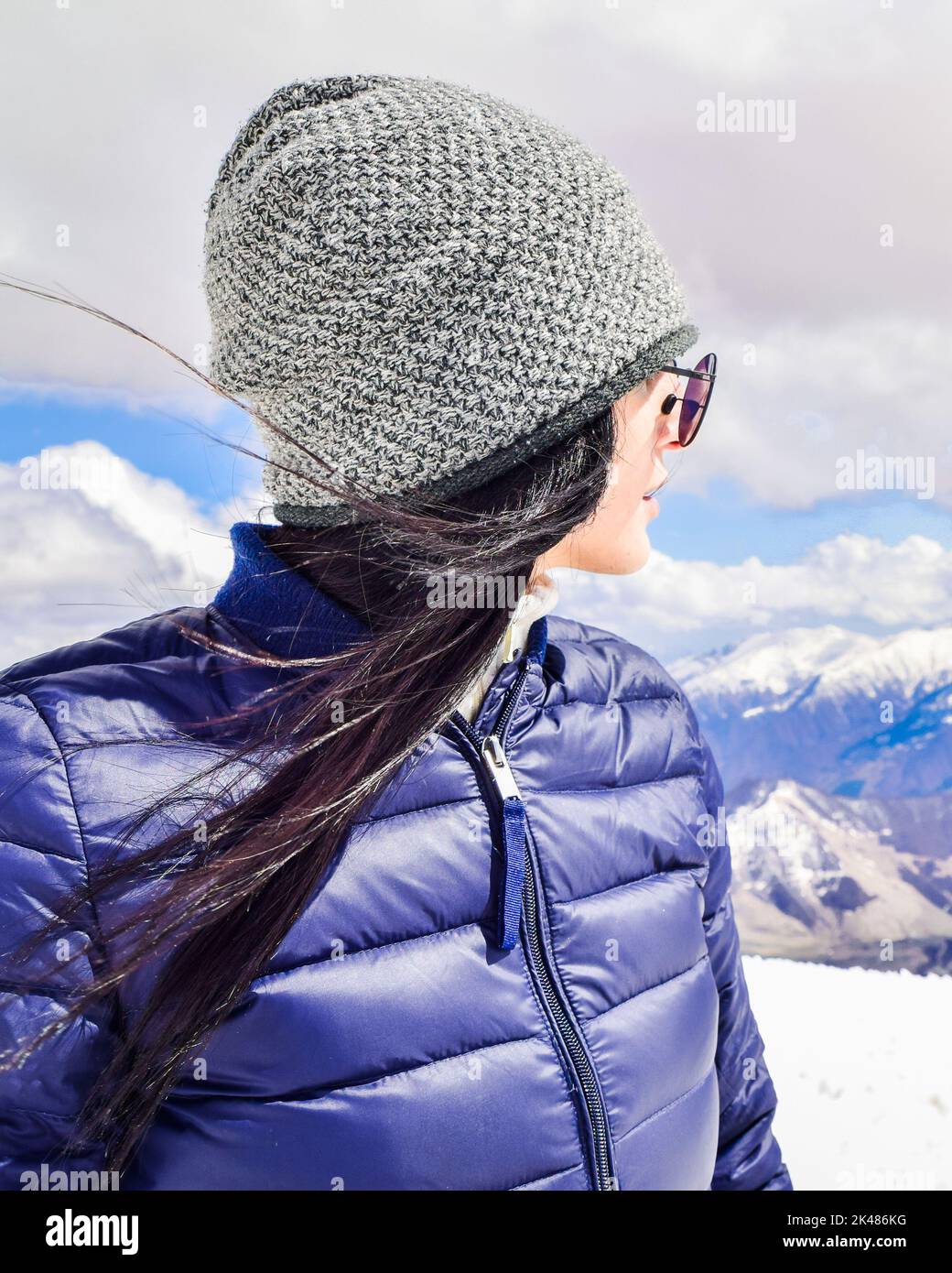 Caucasian female person enjoy winter mountains panorama in sunny ski resort. Right empty blank space copypaste winter solo holiday background Stock Photo