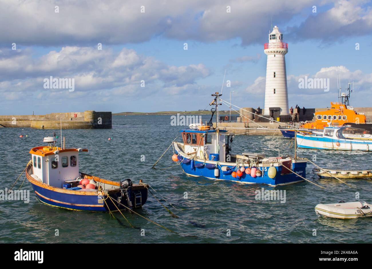 30 September 2022 Boats moored in Donaghadee Harbour, Northern Ireland in the soft sunlight of early autumn under the shadow of the local lighthouse. Stock Photo
