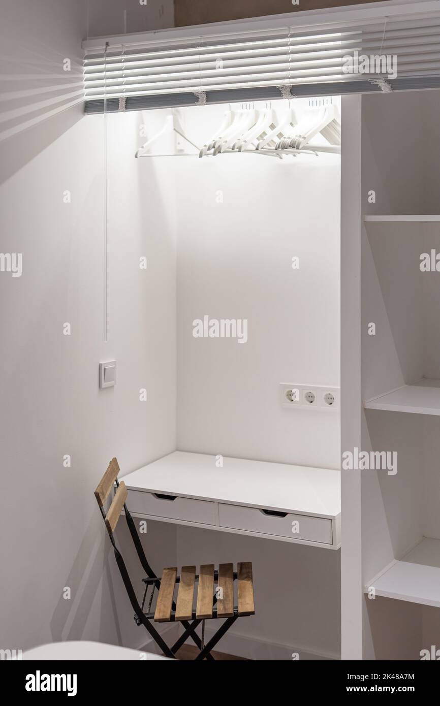 White study table combined with wardrobe with wooden shelves and a