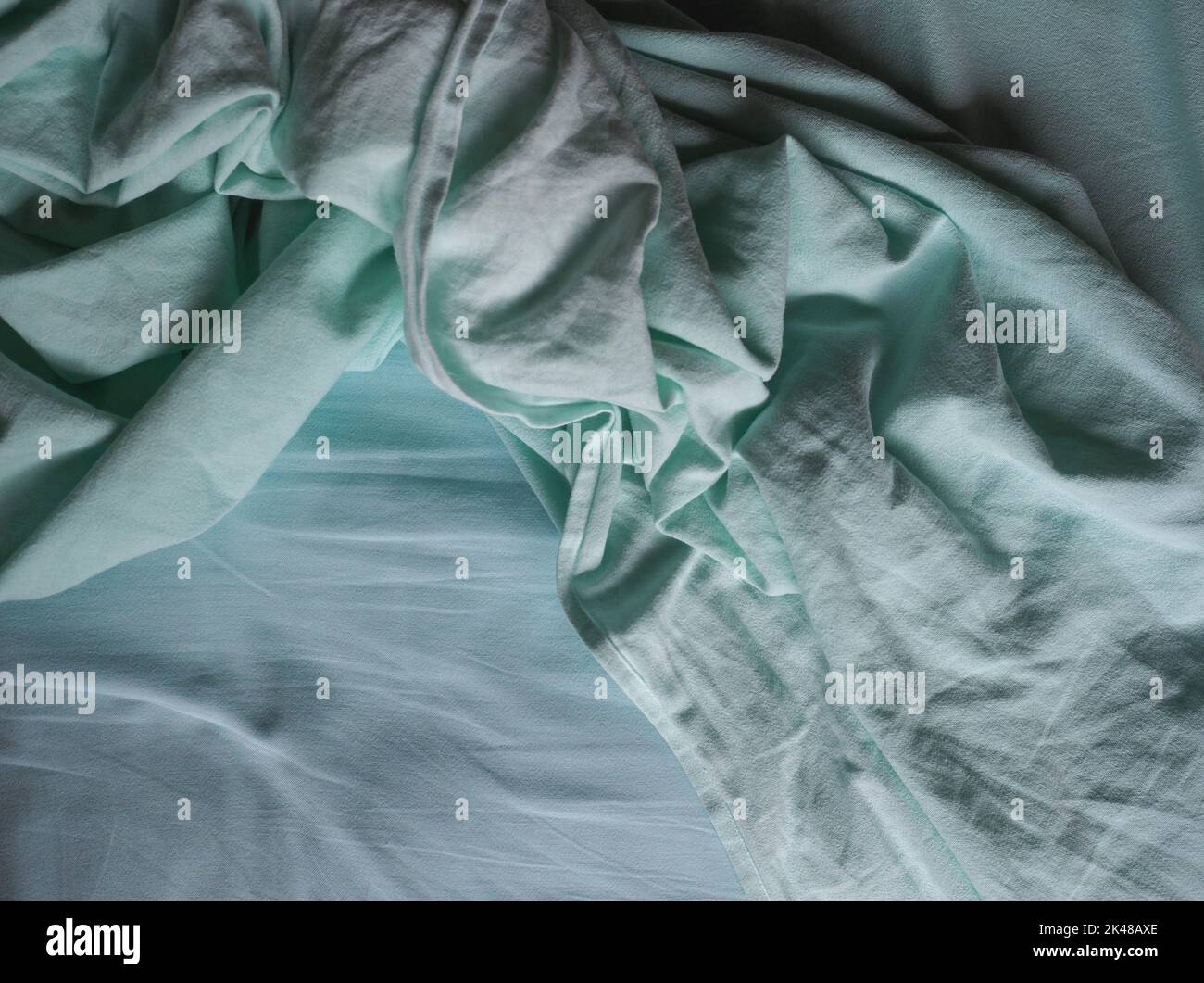 crumpled teal green fabric texture useful as a background Stock Photo