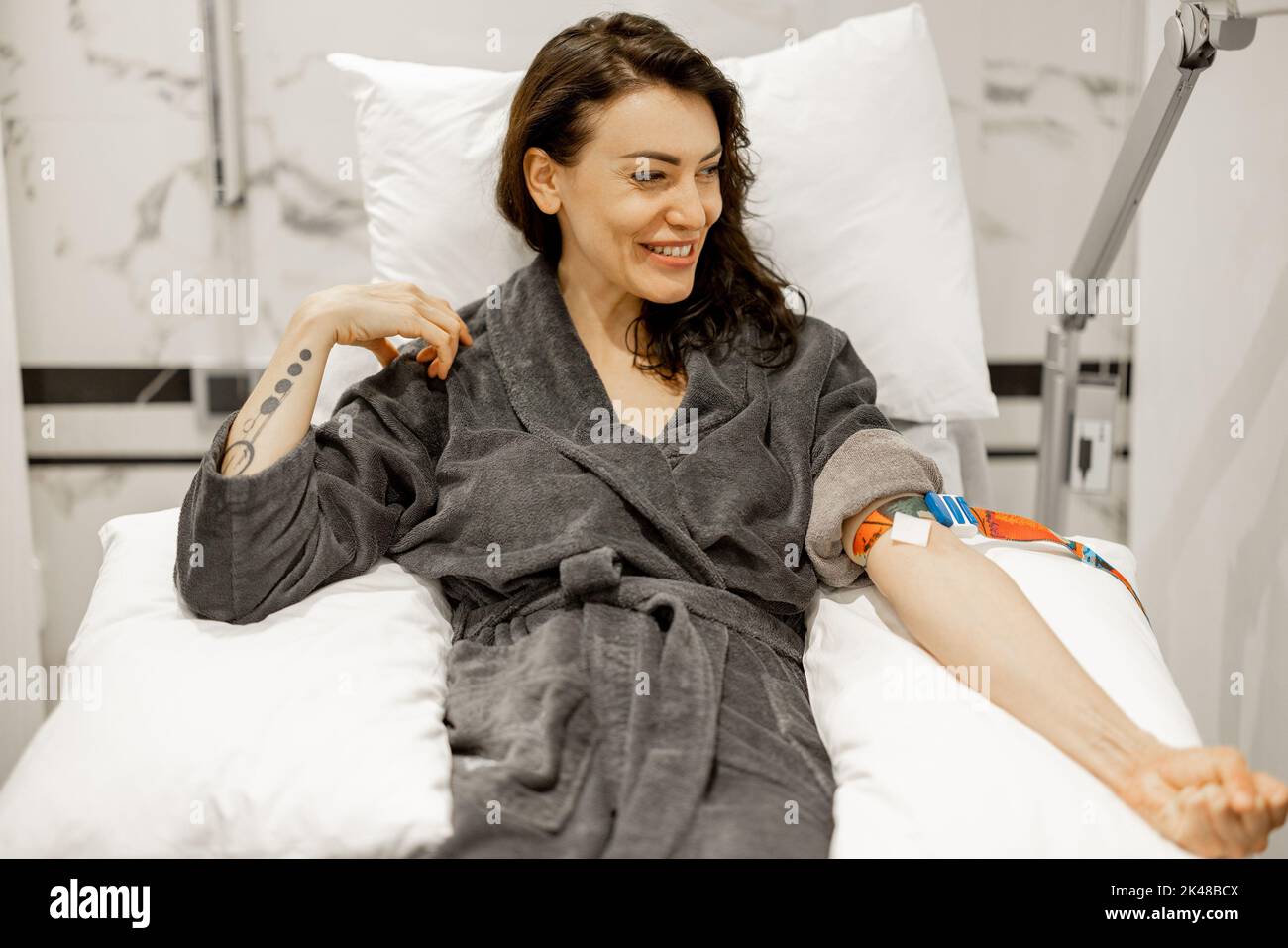 Happy woman in bathrobe after blood test procedure Stock Photo