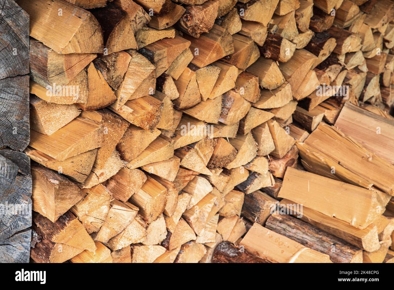 Stock of firewood, a lot of birch wood chocks are stacked in rural barn Stock Photo