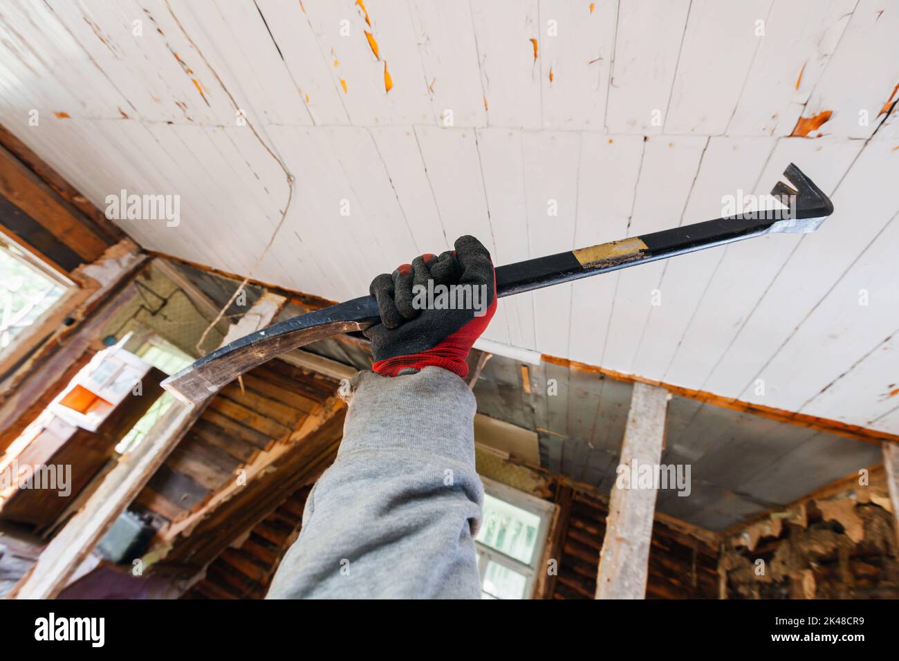Black nail puller in male hand, house demolition is in progress Stock Photo